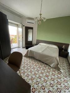 泰卡斯Hotel il Rosone的一间卧室配有一张床和一把椅子