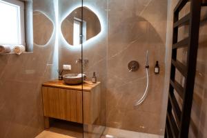 滨湖科伊查赫Pyramidenkogel Lodge的带淋浴、水槽和镜子的浴室