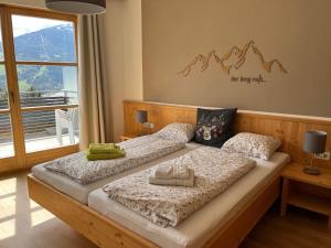 利恩茨Sun Apartments - with Dolomiten Panorama的一间卧室配有两张带枕头的床。