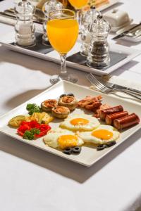 贝尔格莱德阿巴酒店的桌上的一盘早餐食品,加上一杯橙汁