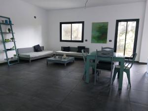 Dar el KoudiaThe Green Blue House的客厅配有桌子和沙发