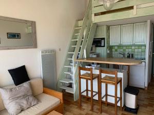 阿格德Appartement calme vue sur l'hérault et la mer的客厅设有楼梯和桌椅