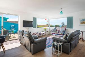 滨海比格伯里Fairwinds,Bigbury on sea ,Three-bed Beach House的客厅配有两张沙发和一台电视机