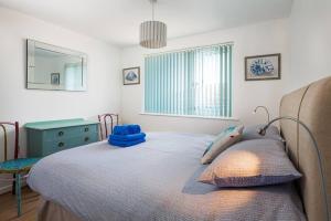 滨海比格伯里Fairwinds,Bigbury on sea ,Three-bed Beach House的一间卧室配有一张床、一张书桌和一个窗户。