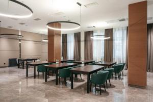 阿拉木图Raavah Aparthotel的用餐室配有桌子和绿色椅子