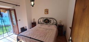 斯波莱托Il Cerqueto的一间卧室配有一张带锻铁床头板的床