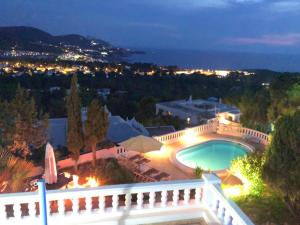 圣何塞德萨塔莱阿5 bedrooms villa at Sant Josep de sa Talaia 900 m away from the beach with sea view private pool and enclosed garden的一座晚上设有游泳池的房子