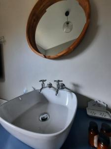 伯诺尼Nel's Cottage, a private and peaceful cottage的浴室水槽上方设有木制镜子