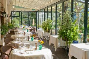 蒙特勒格里昂维多利亚酒店的餐厅设有白色的桌椅和窗户。