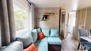加斯泰Camping Officiel Siblu La Réserve的客厅设有蓝色的沙发和窗户。