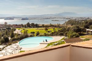 奥尔比亚Hotel dP Olbia - Sardinia的设有一个游泳池的度假村阳台,享有风景