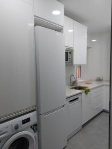 马德里Habitación en Madrid的白色的厨房配有洗衣机和洗衣机