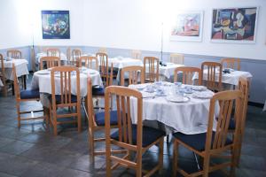 苏安塞斯蒙塔内斯酒店的用餐室配有桌椅和白色的桌布
