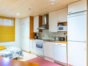 坦佩雷Holiday Home Pispalan elokuvaranta by Interhome的厨房配有白色橱柜和桌子