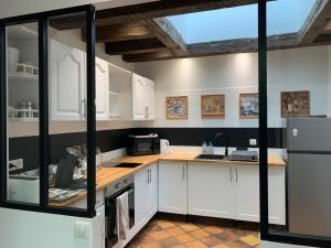 吕讷La Grange d Ave的厨房配有白色橱柜和冰箱。