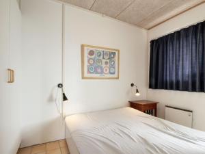 洛肯Apartment Tomte - 70m from the sea in NW Jutland by Interhome的卧室配有白色的床和窗户。