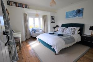 BrookGreystone Cottage - Sea views, short stroll to a beautiful sandy beach的一间卧室设有一张床和一间客厅。