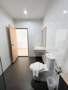 乌隆他尼普坎宁酒店的一间带卫生间、水槽和镜子的浴室