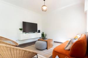 卡斯卡伊斯Cascais Duplex Apartment的一间带电视和沙发的客厅
