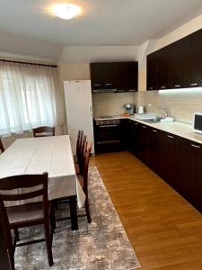 大特尔诺沃Apartment VEDA 2的厨房配有桌椅和白色冰箱。