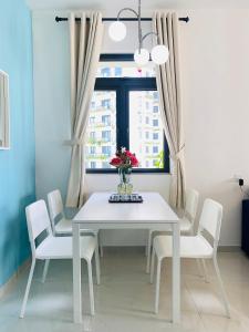 振林山Sea&CityView 2-bedroom Fully Furnished Apartment Forest City #freeWIFI的白色的餐桌、白色的椅子和窗户
