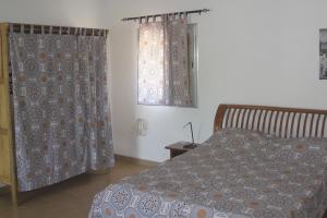 Le Margouillat的一间卧室配有床和带窗帘的窗户