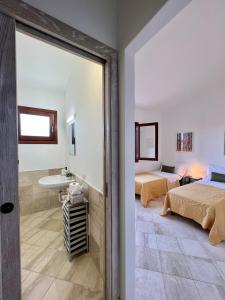 圣特奥多罗Appartamento La Conchiglia a pochi passi dal centro的客房设有两张床和一间浴室。