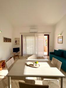 圣特奥多罗Appartamento La Conchiglia a pochi passi dal centro的客厅配有桌子和蓝色沙发