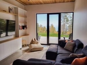 拉马巴耶Le Ruisseau: luxurious villa in Charlevoix.的带沙发和大窗户的客厅