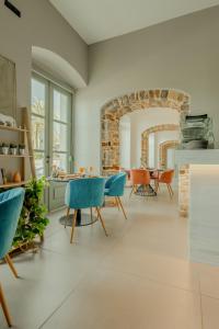 纳夫普利翁Impero Nafplio Hotel & Suites的客厅配有蓝色的椅子和桌子