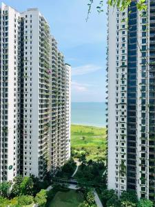 振林山Sea&CityView 2-bedroom Fully Furnished Apartment Forest City #freeWIFI的两座高大的白色建筑,中间有一条路
