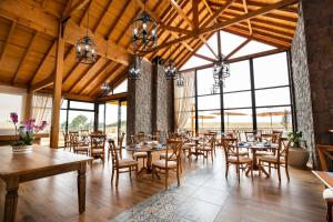 Capão AltoCerro Azul Hotel Fazenda的用餐室设有桌椅和窗户。