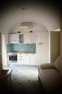 阿纳卡普里villa damecuta B&B的一间厨房,内设白色橱柜和沙发