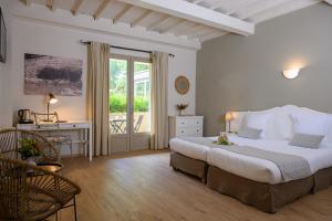 丰维耶贝莱索酒店的一间卧室配有一张床、一张书桌和一个窗户。