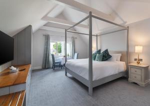 基拉尼Killarney Heights Hotel的一间卧室配有一张天蓬床和一张桌子