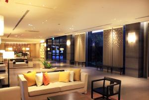 台北北投丽禧温泉酒店的客厅配有白色沙发和黄色枕头。