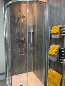FarnworthThe Greens Apartment的浴室内带黄色毛巾的淋浴间