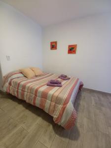 马德普拉塔Al mar!的一间卧室配有带条纹毯子的床