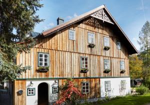 阿尔陶塞Luxuriöses Bauernhaus in Seenähe的大型木制谷仓,上面有窗户和植物