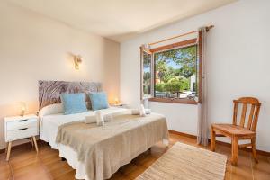 桑帕克Villa Misuco的一间卧室设有一张床、一个窗口和一把椅子