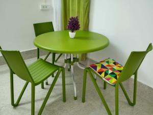 TezpurPurabi's Nest的绿桌,带两把椅子,花瓶