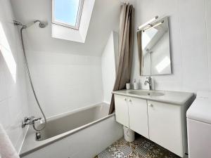 普洛埃默T2 neuf Top Cocooning – Terrasse – Face à la mer的一间带水槽、浴缸和镜子的浴室