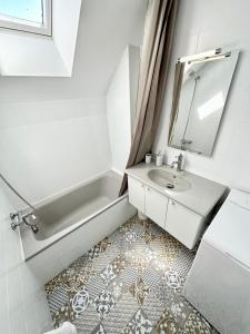 普洛埃默T2 neuf Top Cocooning – Terrasse – Face à la mer的浴室配有盥洗盆、浴缸和镜子