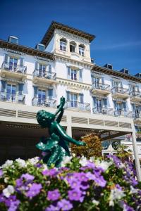 沃韦Grand Hotel du Lac - Relais & Châteaux的花卉建筑前的雕像