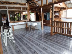 Tua PejatMentawai Bagus Local Homestay的一间铺有木地板的餐厅以及一个带凳子的酒吧