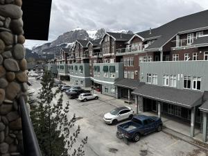 坎莫尔Luxury Two Queen Beds Condo - Grande Rockies Resort Indoor Parking Pool Hot tub GYM的停车场,停车场的汽车停在大楼前