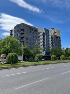 斯科普里Modern Rajcikk Apartment nearby downtown & Vardar river的一个大建筑前的一条空的街道