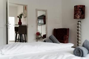 克雷费尔德City Apartments by JUNIK Apartments的一间卧室配有一张床、一把椅子和镜子