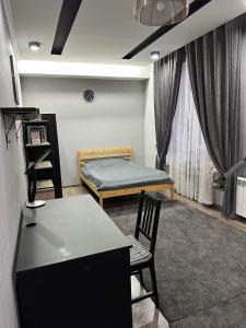 杜尚别Ultra Hostel的配有一张床和一张桌子及椅子的房间