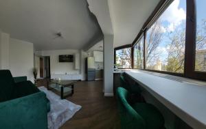 SeleuşRacosim Residentials的客厅设有绿色家具和大窗户